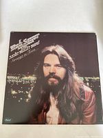 Front cover of Bob Seger & The Silver Bullet Band Stranger In Town vinyl album showing artist portrait and night city background.