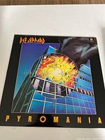 Front cover of Def Leppard Pyromania vinyl record showing building explosion artwork.