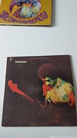 Photo of the Band of Gypsys vinyl record cover showing Jimi Hendrix playing guitar in a dark background with colorful clothing