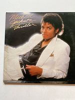 Front cover of Michael Jackson Thriller vinyl record showing portrait of Michael Jackson in white suit.