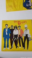 Front cover of The B-52's vinyl album showing band members posing in front of a yellow background.