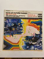 Front cover of the vinyl album 'Days Of Future Passed' by The Moody Blues with orchestra, showing colorful abstract art and album details.