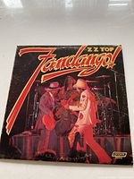 Front cover of ZZ Top Fandango! album, showing live stage performance in color with title and band name.