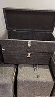 Open and closed views of two grey acoustic cloth covered transport cases with metal corners and handles.