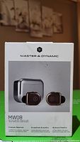 Front view of Master & Dynamic MW08 product box showing earbuds and charging case image along with branding and product name.