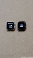Two Apple Watch Series 3 units powered on. Left watch shows setup screen prompting connection to iPhone. Right watch shows low battery message.
