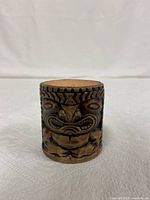 Front view of the brown tiki shot glass showing the carved tiki face design.