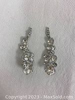 Photo of pair of long crystal dangling earrings with clear faceted stones on silver-tone metal.