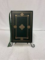 Front cover view of the limited edition W.H. Auden Collected Poems 1978 hardcover book showing gold ornate detailing on green cover and attached green ribbon bookmark.