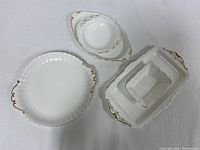 Three white ceramic Royal Albert Val D'or china pieces with gold trim: round plate, oval dish, rectangular divided dish.