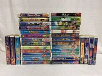 Front view of a collection of 31 Disney VHS tapes stacked in three rows, titles visible on spine labels.