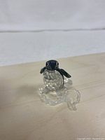 Crystal penguin figurine facing front and slightly sideways showing body, wings and ice base