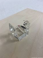 Angled view of the Swarovski crystal pig figurine seated at the computer desk on a wooden surface.