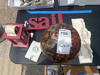 Photo of the lot items including the take-apart globe, red tea light lantern, cream resin shelf, and 'sail' hooks on a black surface