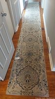 Full length shot of the floral runner rug laid out in a hallway showing overall design and size