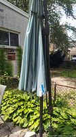 Closed view of the canvas umbrella fabric with visible stains wrapped around the metal stand