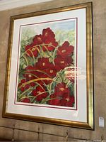 Front view of the framed artwork with red flowers, gold frame and white matting with red border.