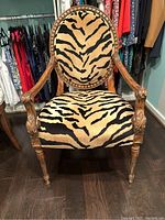 Front view of zebra print accent chair showing carved wooden frame and fabric upholstery