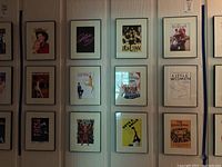 Wall display of eleven framed Broadway show covers arranged in rows and columns, showing titles and artwork clearly.