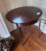 Oval mahogany drop leaf table in extended position showing the entire table surface and legs.