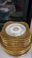 Stack of gold rimmed Bavarian plates showing intricate gold pattern on the front plate