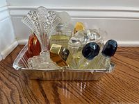 Photo showing seven assorted vintage perfume bottles including ornate large glass stopper, gold and blue caps