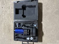Open hard case showing blue optical tube, fork mount and accessory foam compartments