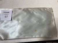 Closed soft pouch or bag for jewelry storage with auction lot label 97