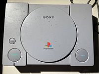 Sony PlayStation original console showing top view with power, reset, and open buttons
