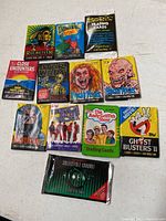 Vintage and nostalgic collectible trading card packs unopened lying flat on white surface, including Star Wars, Close Encounters, Fright Flicks, Boris, Dragon's Attack, Andy Griffith Show, Ghostbusters II packs.