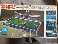 Box showing Tudor NFL Electric Football game with graphics and product details