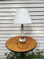 Full view of the table lamp showing polished stone base and fabric lampshade on a wooden surface.