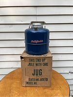 Blue metal insulated jug sitting on original cardboard box, showing Pathfinder decal and part of box text.
