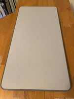 Top view of a rectangular white table top with grey edges