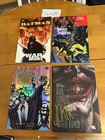 Front covers of four Batman graphic novels: War Drums, Death of the Family: Madness, The Long Halloween Special Edition, Joker by Brian Azzarello