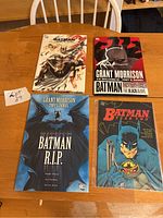 Front cover photo of 4 Batman graphic novels showing detailed cover art and titles.