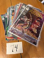 Stack of Green Arrow comic books from issue 1 to 53 in protective sleeves placed on wooden table.