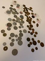 Photo showing a spread of mostly British old coins, various sizes and denominations, some in protective plastic holders