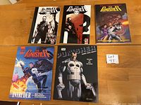 Top view of five graphic novels with various Punisher-themed covers, including action and skull motifs.