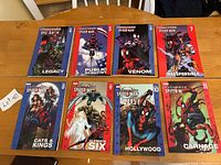 Full set of Ultimate Spider-Man comic books volumes 4-11 laid out face up on a wooden table, showing front covers with colorful Marvel artwork.