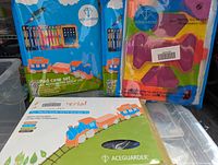 Four new iPad tablet protectors in original packaging with ACEGUARDER branding and colorful labels including a blue, orange, and green train illustration.