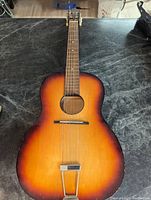 Full view of the acoustic guitar showing sunburst finish and overall shape