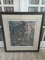 Framed original print titled "A Narrow Escape" by George Mclean depicting a bird of prey and prey in natural foliage, dark frame with matting.