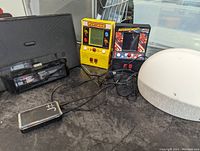 View showing Pac-Man and Asteroids handheld retro video games, Sony iPod alarm clock radio, Bluetooth converter, and round light fixture.
