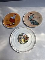 Front view of three Norman Rockwell decorative plates with Christmas themes, showing detailed artwork and inscriptions on each plate.