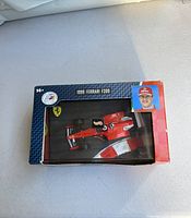 Front view of the boxed 1999 Ferrari F399 diecast model showing car inside with Michael Schumacher image and branding.