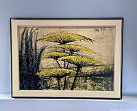Framed Bernard Buffet print showing the artwork with yellow flowers and dark green foliage, mounted on a blue surface.