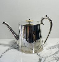 Full side view of the vintage silver-plated teapot showing overall shape, spout, and handle.