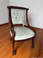 Front and side view of early empire style chair showing tufted upholstered back, mahogany frame, and claw feet without castors.