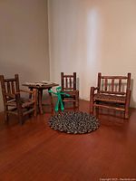 Full view of the miniature Old Hickory furniture including two chairs, one double settee, round woven rug in front, and Gumby figure.